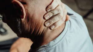 man holding neck - Common Injuries from Car Accidents - Noll Law Office