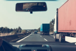 car driving next to semi truck